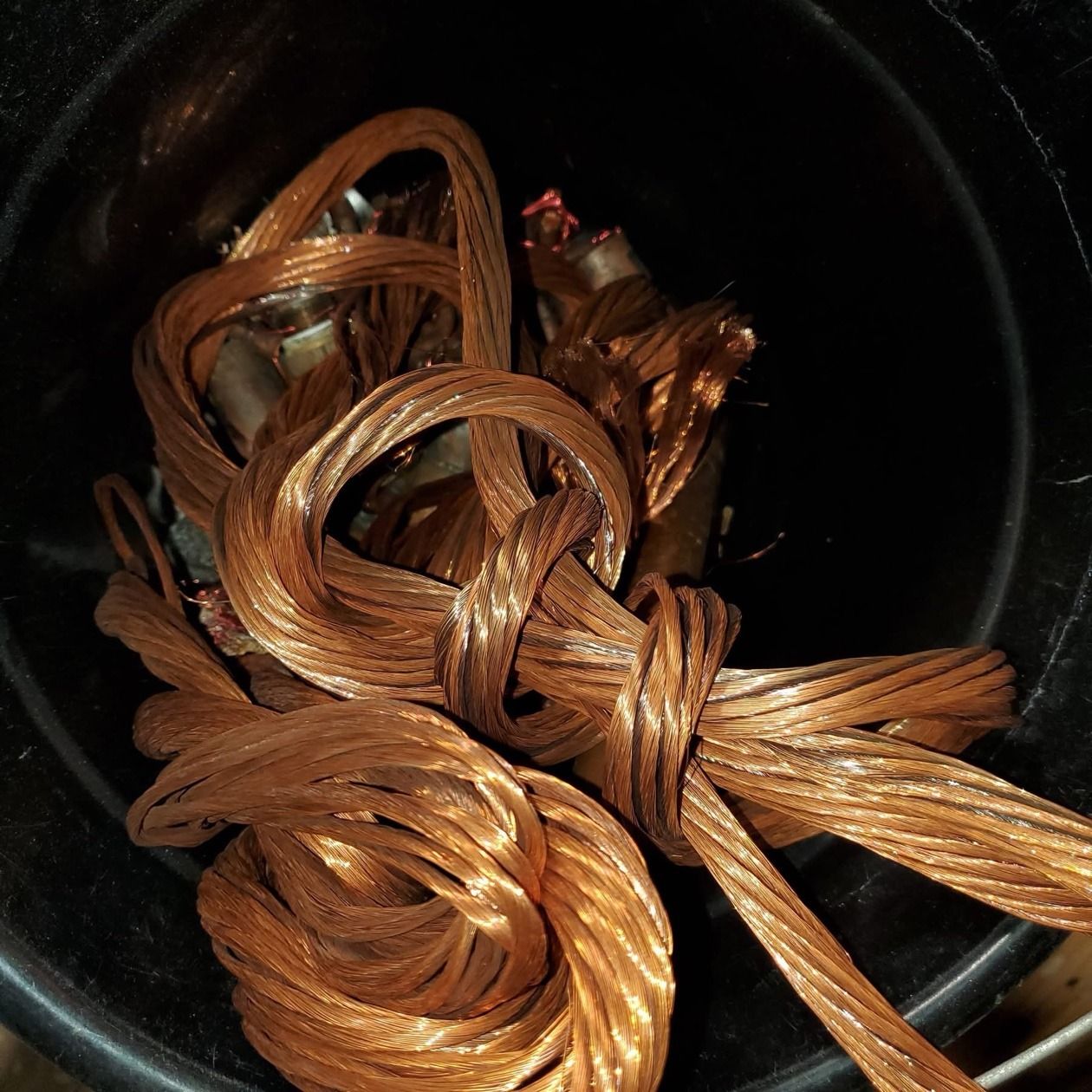 Bucket of tied bundles of stripped stranded bare bright copper wire