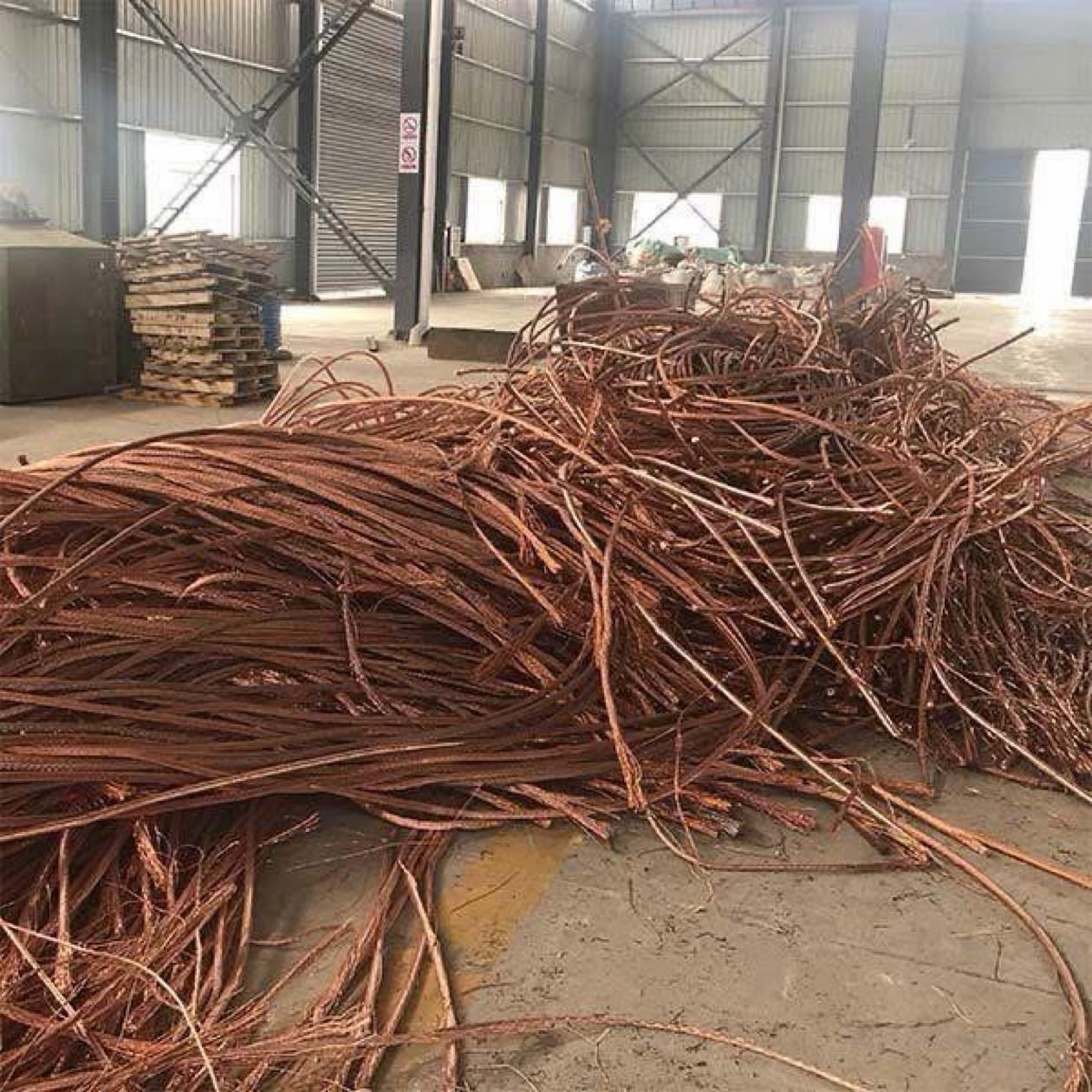 Warehouse floor pile of stripped bare bright copper wire strands