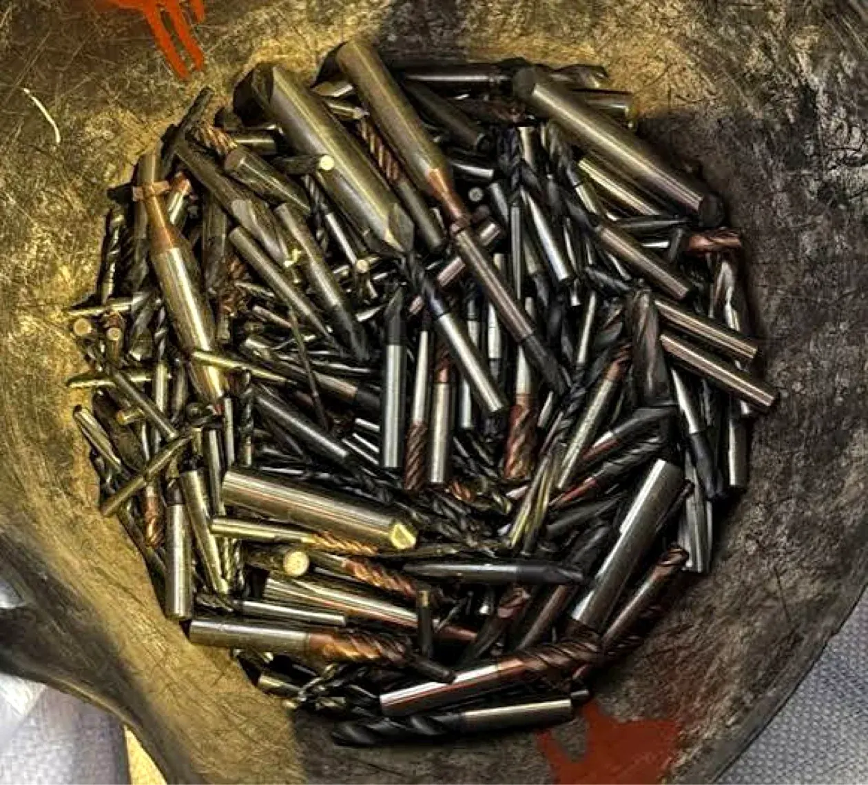 Bucket of used carbide end mills and drills that Ironcrest buys
