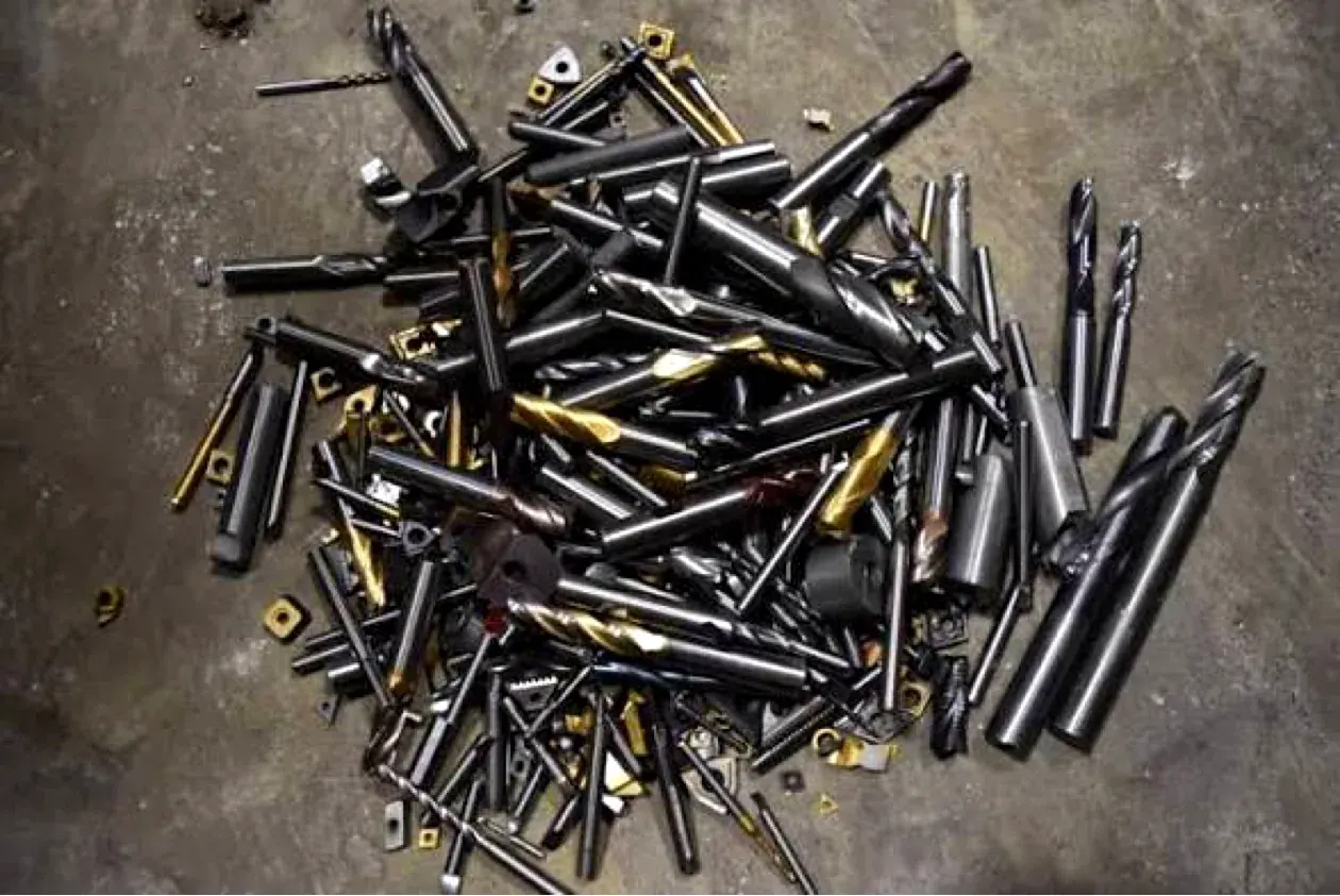 Pile of used end mills on a concrete floor